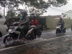 ngendara-sepeda-motor-saat-menerjang-genangan-air-ditengah-hujan-turun_20171202_232504.jpg