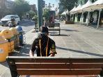 petugas-jogoboro-siapkan-tali-penyekat-di-kursi-yang-berada-di-jalan-malioboro.jpg
