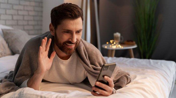 PANTUN JANGAN BEGADANG - Potret pria videocall lewat smartphone dari Freepik.com, Rabu (16/4/2025). Lihat kumpulan pantun jangan begadang berikut ini, nasihat jaga kesehatan dengan tidur yang cukup.