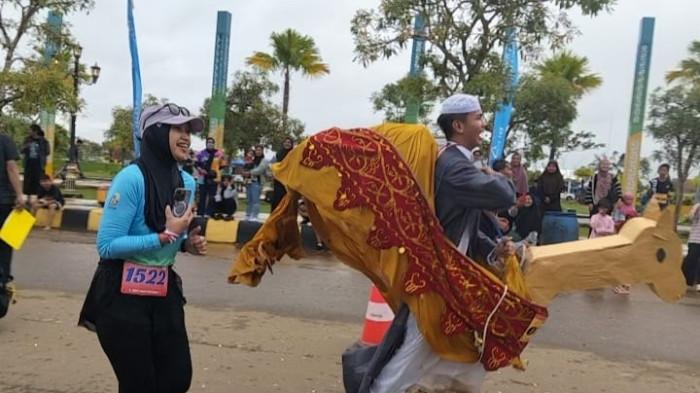 BERLARI DENGAN KOSTUM UNTA - Peserta Tana Tidung Menturus Season 3 saat berlari mengenakan kostum unta di RTH Djoesoef Abdullah, Jalan Perintis, Tideng Pale, Kecamatan Sesayap, Kabupaten Tana Tidung, Kaltara, Sabtu (22/11/2025). Sempat ingin menyerah tapi termotivasi dari teriakan ibu-ibu. (TribunKaltara.com/Rismayanti)