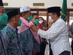 memasang-sal-rombongan-jemaah-haji-nunukan-sebagai-tanda-melepaskan-52-calon-haji.jpg