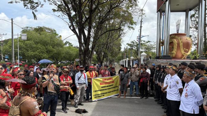 MENGGELAR AKSI - Puluhan masyarakat yang tergabung dalam Aliansi Masyarakat Dayak Bersatu menggelar aksi unjuk rasa di depan Kantor Gubernur Kalimantan Tengah, Rabu (12/11/2025).