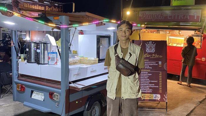 KULINER - Riski Chandra Gunawan, pemilik Ming Truck, tersenyum di depan bajaj coklat modifikasinya di Jalan George Obos, Senin (20/10/2025). Bajaj yang biasa terlihat di Jakarta ini kini jadi magnet kuliner di Palangka Raya.