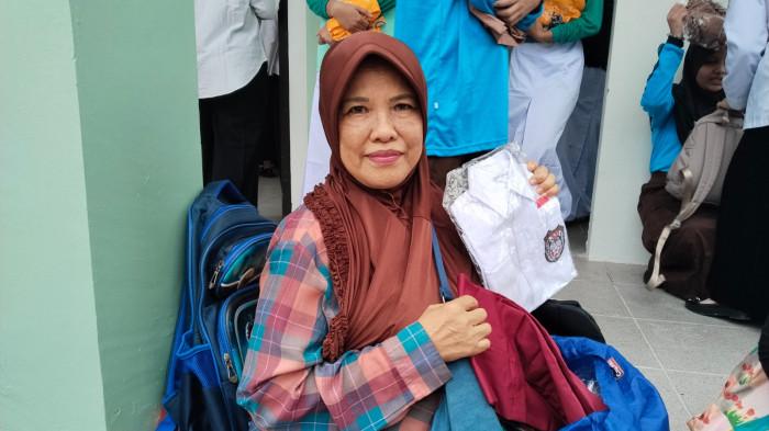 SERAGAM GRATIS - Nani salah satu orang tua murid warga Balikpapan Tengah yang sangat senang menerima seragam gratis dari Pemkot Balikpapan. (TRIBUNKALTIM.CO/SITI ZUBAIDAH)