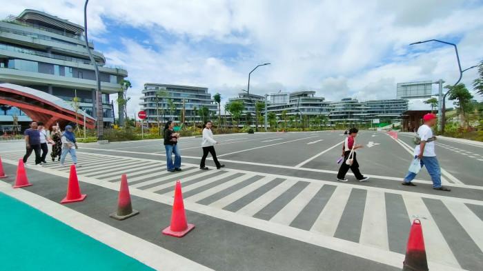 IKN DI KALTIM - Masyarakat berkunjung ke bagian dalam kawasan IKN Nusantara di Kaltim, dari satu gedung ke gedung lain harus berjalan kaki, tidak tersedia angkutan kendaraan bermotor, 5 Juli 2025. Mereka yang berjalan kaki bisa rasakan manfaat dari sisi kebugaran tubuh.  