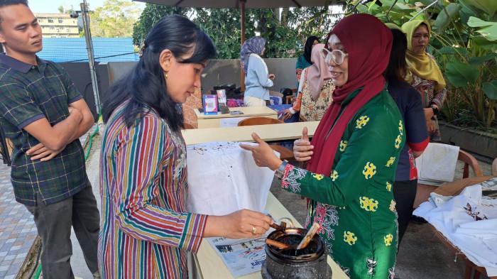 salah satu pengunjung mencoba membatik di  tenan peserta pada acara hari batik nasional di Fourpoints by Sheraton Hotel Balikpapan