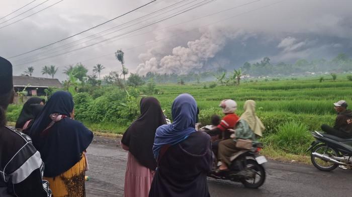 GUNUNG SEMERU ERUPSI - Warga memantau erupsi Gunung Semeru dari depan rumahnya, Rabu (19/11/2025). Gunung Semeru terletak di Jawa Timur dengan tinggi 3.676 mdpl. Cek lokasi, sejarah, dan info erupsi Semeru hari ini untuk update lengkap.(KOMPAS.com/MIFTAHUL HUDA)
