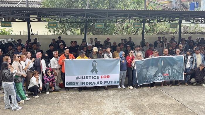 PENEMBAKAN DI THM - Suasana di Pengadilan Negeri Samarinda mulai tegang pada Rabu (28/1/2026) sore. Ratusan Keluarga dari Dedy Indrajit Putra membawa dua spanduk berlogo perdamaian dengan tulisan mencolok #Justice For Dedy Indrajid Putra.