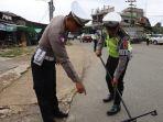 20240124_Kasat-Lantas-Polres-Kubar-saat-menyisir-jalan-untuk-mencari-paku.jpg