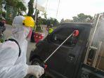 petugas-dari-palang-merah-indonesia-pmi-menyemprotkan-disinfektan-ke-setiap-mobil.jpg
