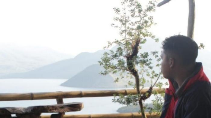 Salah seorang pelancong sedang menikmati keindahan bentangan bebukitan di Perairan Flores Timur dari tanjung Eputobi.