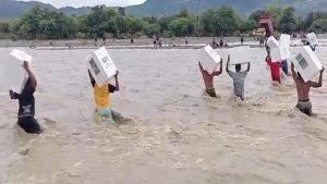 Tampak-petugas-pemilu-dan-warga-saat-menerobos-banjir-di-Kali-Bonpo.jpg
