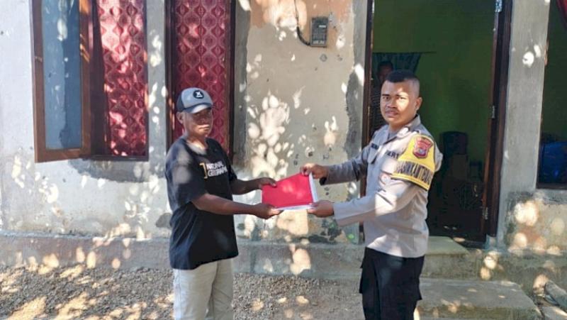 Bhabinkamtibmas Polsek Lobalain Bagikan Bendera Merah Putih kepada Warga 