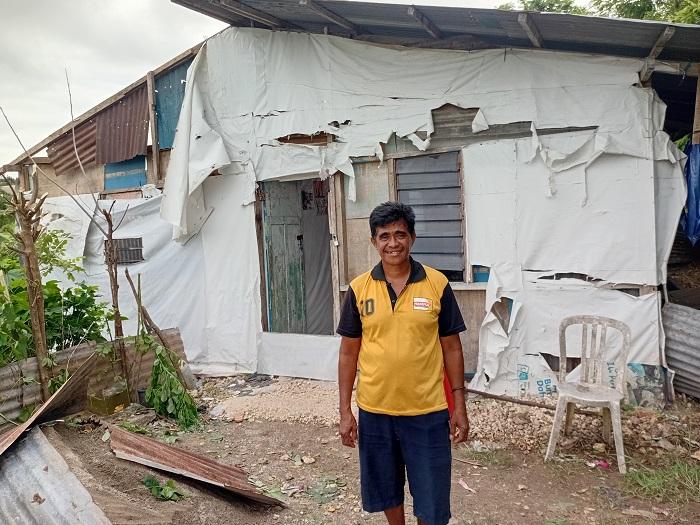 Salah-seorang-warga-di-RT-14-pose-di-depan-rumahnya.jpg