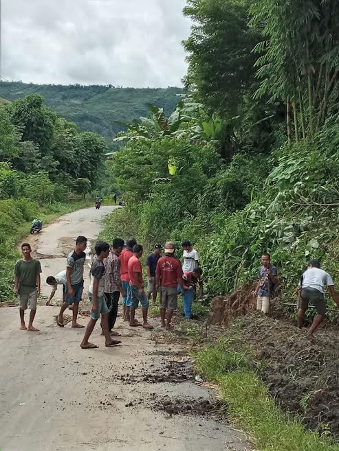 Warga Gotong-Royong Bersihkan Rumput di Jalan