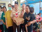 Ketua-Kwartir-Daerah-Gerakan-Pramuka-NTT-Sinun-Petrus-Manuk-menyerahkan-bantuan-makanan.jpg