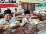 Pelajar-SD-Negeri-Cangkringrembang-Kabupaten-Demak-menunjukkan-menu-MBG.jpg