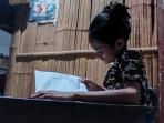 Siswi-SDN-Tes-Olivia-Kolo-sedang-belajar-di-bawah-pijar-bola-lampu-di-ruang-tamu-rumah-mereka.jpg