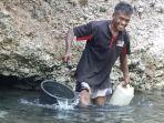 Warga-Dusun-Wairbura-Desa-Darat-Gunung-Sikka-NTT-ambil-air-di-dinding-bukit.jpg