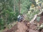 Warga-menggotong-sepeda-motor-melewati-jalan-yang-tertimbun-longsor.jpg