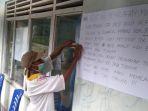 warga-tuasene-kabupaten-tts-sedang-menempelkan-poster.jpg