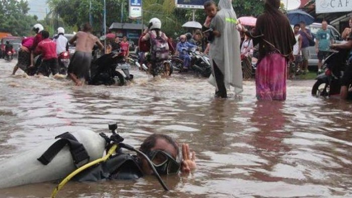 Pria Ini Menyelam di Tengah Genangan Air Banjir di Jalan Raya