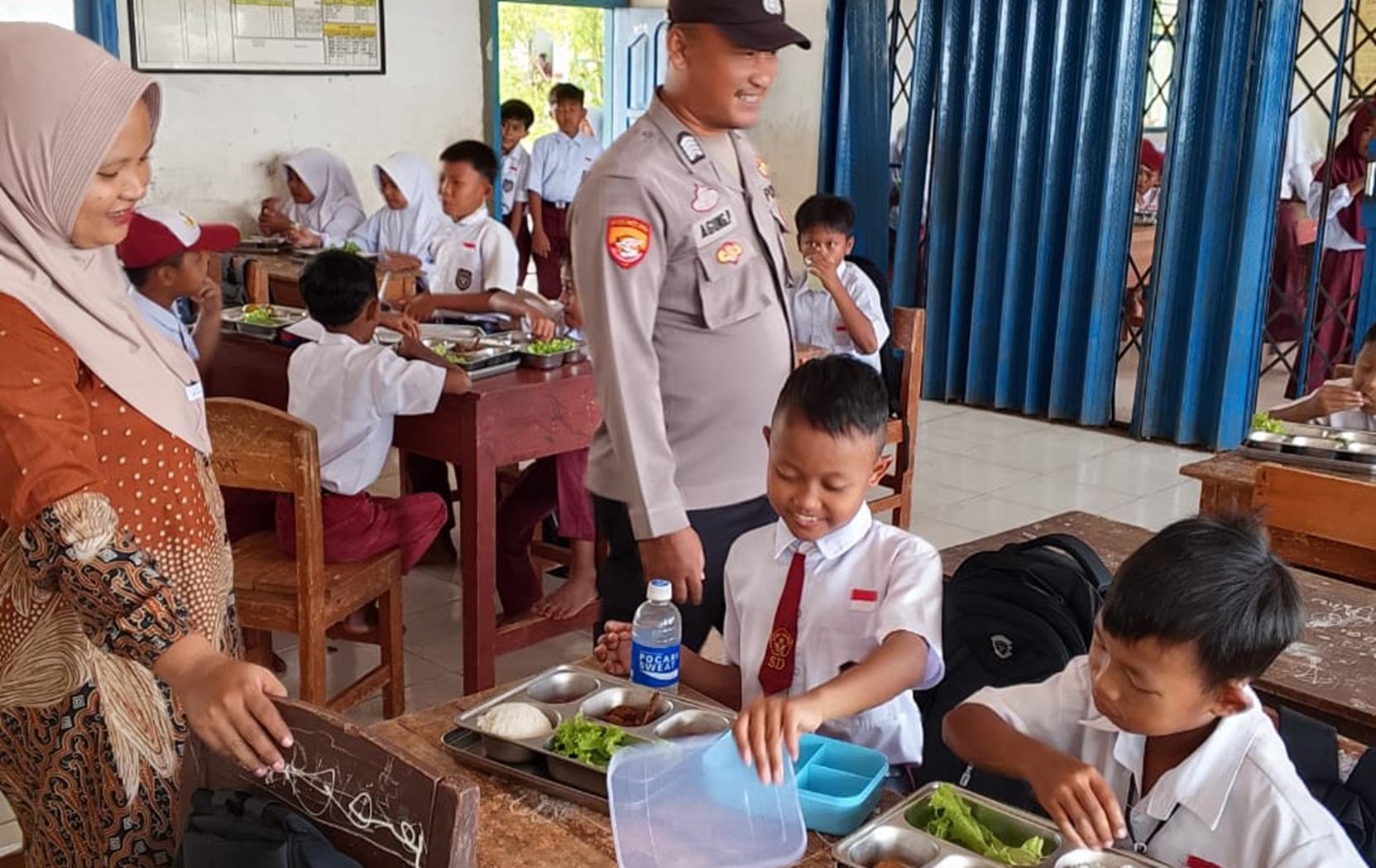 Bhabinkamtibmas Polsek Negara Batin Monitoring MBG Kepada Pelajar di Sekolah  