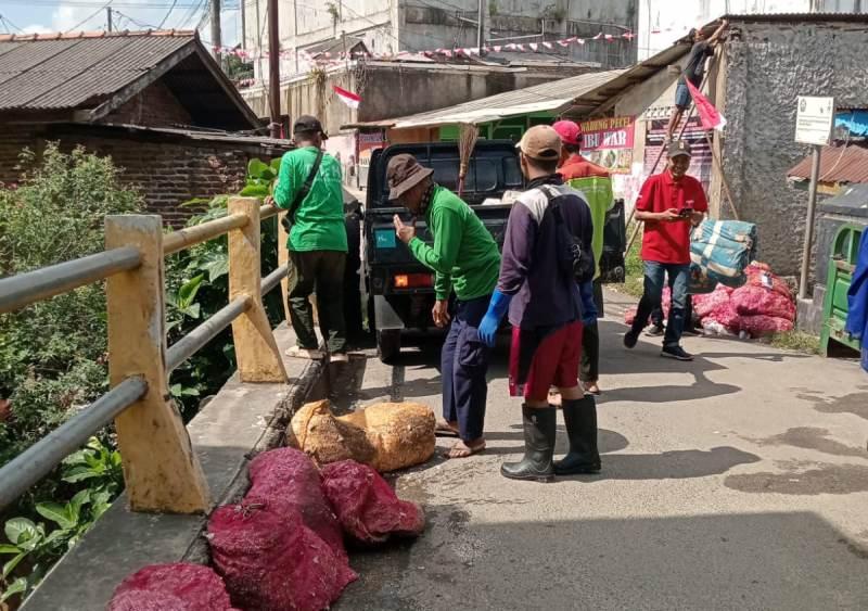 Petugas-membersihkan-sampah-limbah-kulit-bawang-di-aliran-kali-Pasar-Pasir-Gintung.jpg