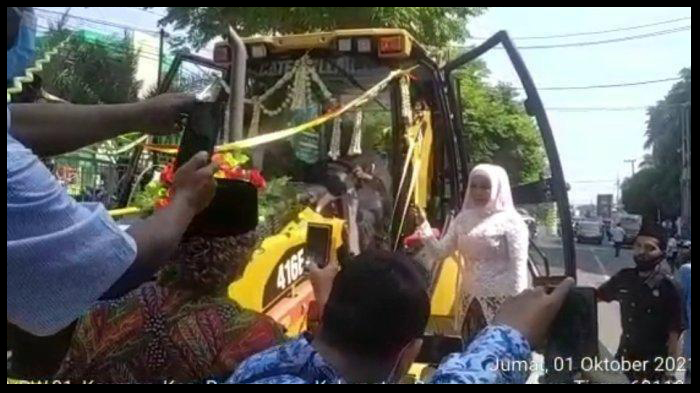 aksi-nyentrik-pengantin-diarak-alat-berat-lengkap-dengan-hiasan-pita-lihat-sosoknya.jpg