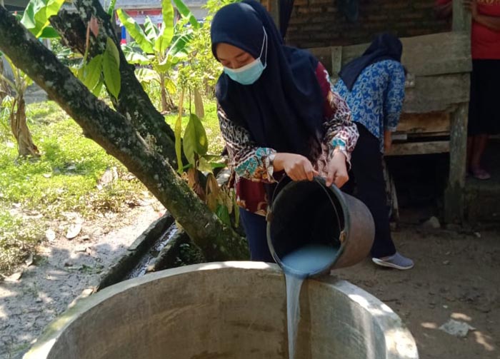 petugas-kesehatan-dari-puskesmas-berikan-larutan-kaporit-ke-sumur-warga.jpg