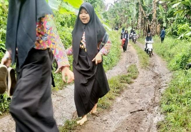 siswi-berjalan-kaki-lewat-jalan-rusak.jpg