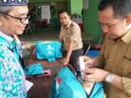 petugas-sedang-memeriksa-makanan-yang-menjadi-barang-bawaan-calhaj_20150827_195329.jpg