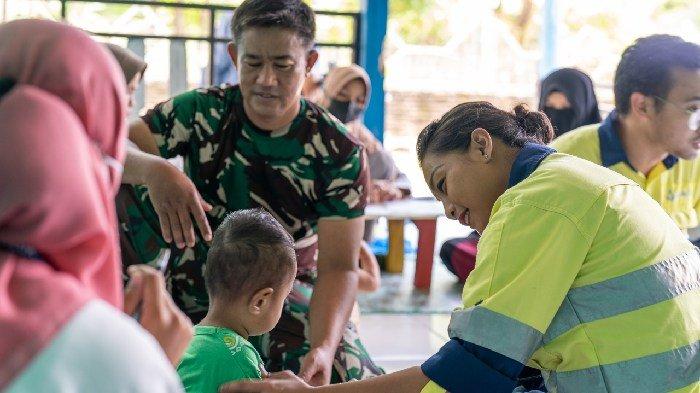 One of AMMAN's female employees checks the condition of a child in West Sumbawa Regency.