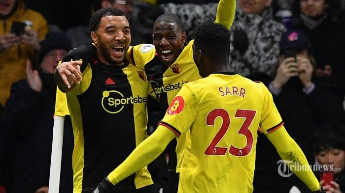 PEMAIN WATFORD - Striker Watford asal Inggris, Troy Deeney (kiri) melakukan selebrasi bersama rekannya, pemain tengah asal Prancis, Abdoulaye Doucoure (tengah) usai mencetak gol ketiga bagi timnya ke gawang Liverpool dalam laga lanjutan Liga Inggris 2019/2020 di Stadion Vicarage Road, Watford, London Utara, Inggris, Minggu (1/3/2020) dini hari WIB. Liverpool kalah telak 0-3 dan ini merupakan kekalahan pertama The Reds di Liga Inggris pada musim ini sekaligus menghentikan rekor tak terkalahkan yang dicapai Liverpool.