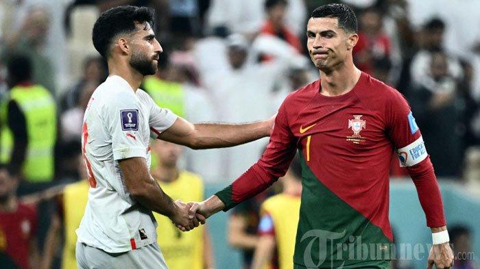 Penyerang Portugal Cristiano Ronaldo menyapa bek Swiss Eray Comert setelah lolos ke babak berikutnya setelah mengalahkan Swiss 6-1 dalam pertandingan sepak bola babak 16 besar Piala Dunia Qatar 2022 antara Portugal dan Swiss di Stadion Lusail di Lusail, utara Doha. Selasa (6 Desember 2022).