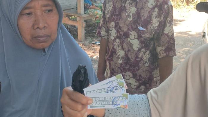 Dua-orang-ibu-ibu-menunjukkan-sembako-dengan-stiker-Pathul-Nursiah.jpg