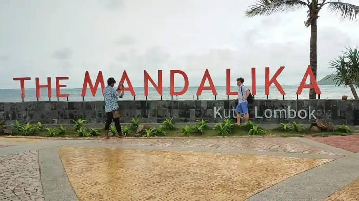 Dua-orang-sedang-berfoto-di-Pantai-Kuta-Mandalika.jpg