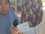 Dua-orang-ibu-ibu-menunjukkan-sembako-dengan-stiker-Pathul-Nursiah.jpg