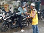 Warga-membayar-parkir-secara-tunai.jpg