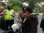 petugas-kepolisian-menggeledah-barang-barang-milik-dua-pemuda-dalam-penyekatan-malam-tahun-baru.jpg