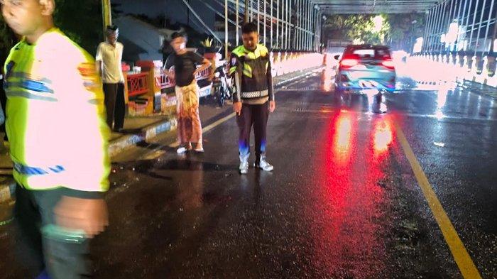 OLAH TKP - Anggota Satlantas Polres Sampang saat berada di lokasi ditemukannya pria tergeletak tak sadarkan diri di sekitar Jembatan Laris, Jalan Wahid Hasyim, Kelurahan Gunung Sekar, Kabupaten Sampang, Madura, Jumat (15/5/2026) dini hari. Setelah tiba di rumah sakit, petugas medis menyatakan korban telah meninggal dunia. 