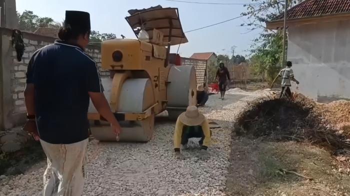 PENDUDUK VIRAL - Mat Yasin (kopiah hitam) saat meninjau lokasi pembangunan jalan Desa Madulang Kecamatan Omben, Kabupaten Sampang, Madura dengan uang pribadi sebesar Rp 2 miliar, Rabu (22/10/2025).