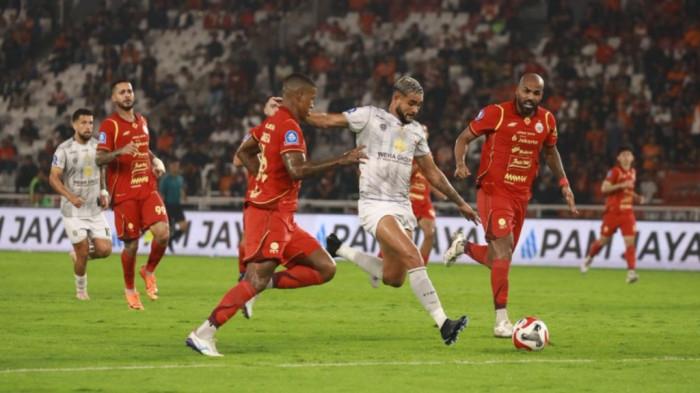 TENDANG - Striker Madura United, Junior Brandao, (kaus putih) melakukan tendangan dihadang pemain Persija di Stadion Utama Gelora Bung Karno (GBK), Jumat (23/1/2026) malam. Laga berakhir 2-0 untuk Persija.