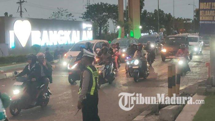 REKAYASA LALU LINTAS - Deretan kendaraan roda dua dan empat memasuki pintu keluar akses Suramadu pada H-1 Hari Raya Iduladha, Selasa (26/5/2026) petang. Kondisi ini direspons Satlantas Polres Bangkalan dengan memberlakukan rekayasa lalu lintas di Simpang Empat Pos Sendang akses Suramadu untuk mengurangi penumpukan kendaraan.
