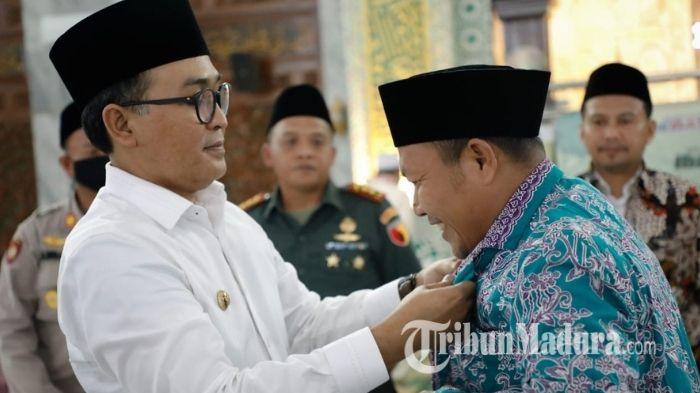 Bupati-Pamekasan-Baddrut-Tamam-kiri-saat-memakaikan-pakaian-secara-simbolis-haji.jpg
