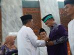 Bupati-Pamekasan-KH-Kholilurrahman-memakaikan-jas-ke-perwakilan-calon-jemaah-haji-CJH.jpg