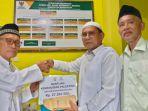Ketua-PD-DMI-Bangkalan-KH-Mondir-Rofii-menyerahkan-hasil-donasi-dari-para-takmir.jpg