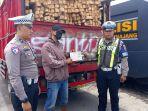 Polisi-menunjukkan-truk-kayu-dengan-nomor-polisi-BK-8259-BJ-yang-telah-diamankan.jpg
