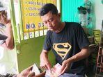 Saat-Agus-Noris-menunjukkan-uang-palsu-yang-dipakai-untuk-menipu-nenek-di-Surabaya.jpg