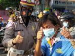 personel-satlantas-polres-pamekasan-saat-memberikan-masker-kepada-pengendara-motor.jpg